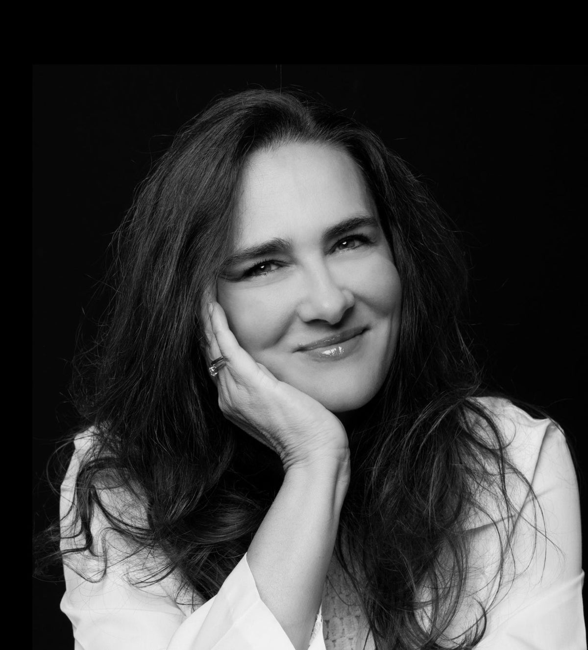 Black and white portrait of a woman with a soft smile, wearing a white lab coat.